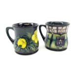 Two Moorcroft mugs of waisted form