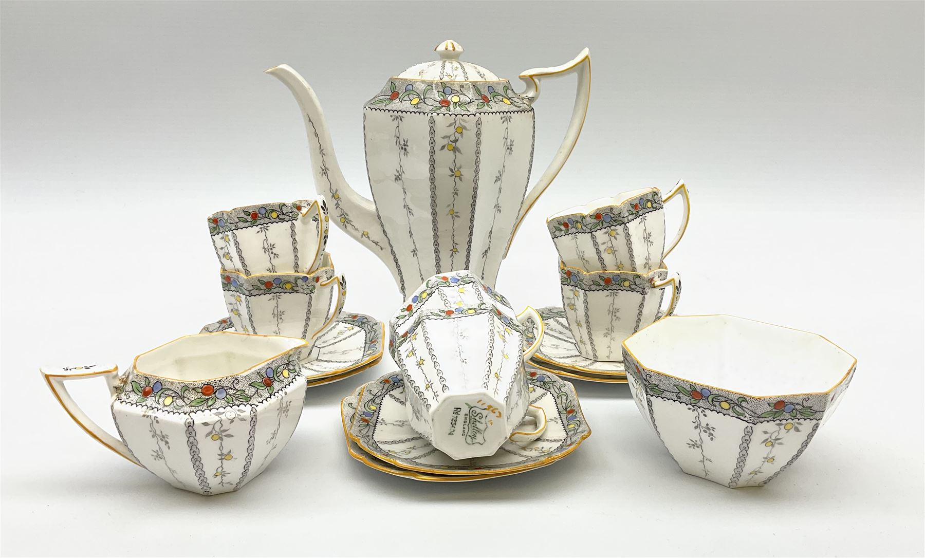 An Art Deco Shelley Queen Anne shape coffee set for six decorated in the Fruit Border pattern