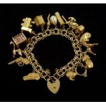 Gold link bracelet with heart locket and fifteen 9ct gold charms including train