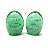 A pair of Victorian green glass dump paperweights