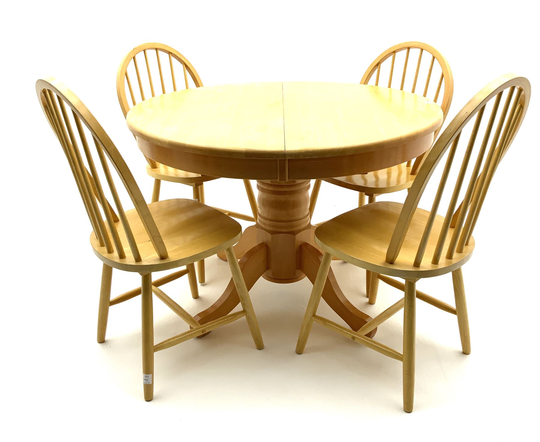 Light wood circular extending dining table and four hoop back chairs