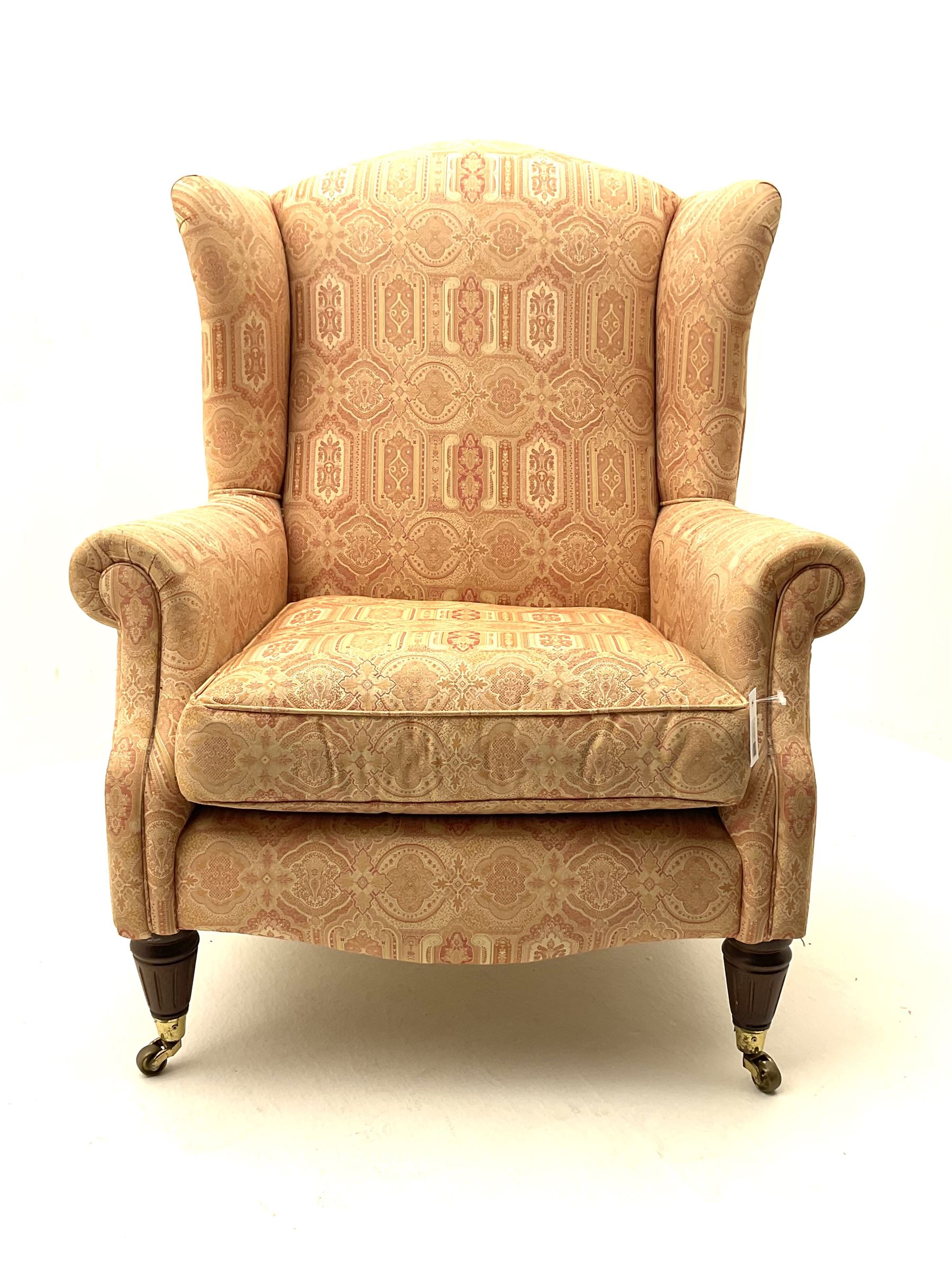 Late 20th century traditional shaped wingback armchair upholstered in pale pink patterned fabric