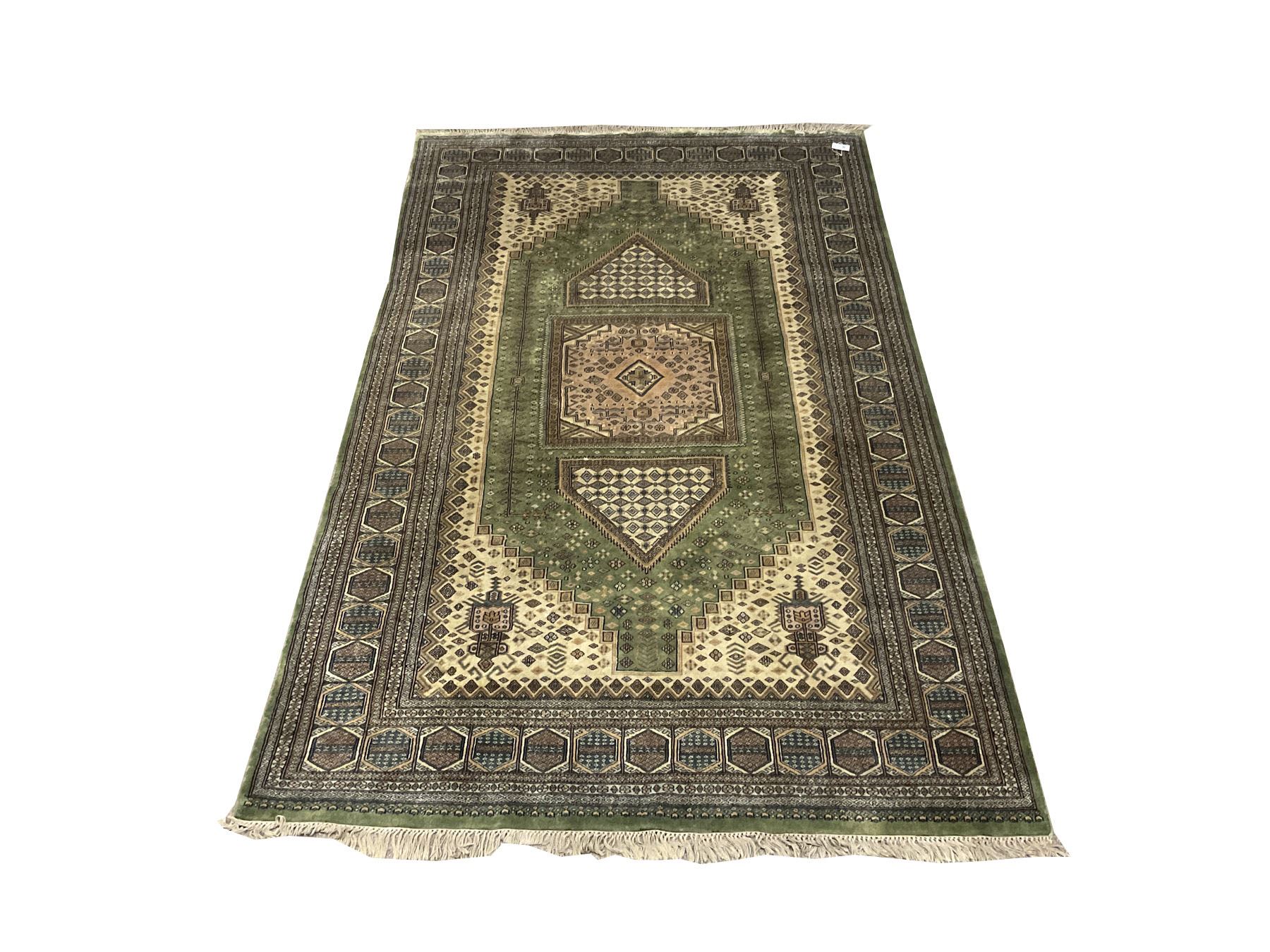 Persian design green and beige ground carpet