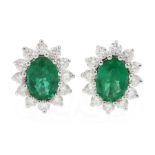 Pair of 18ct white gold oval emerald and diamond cluster stud earrings