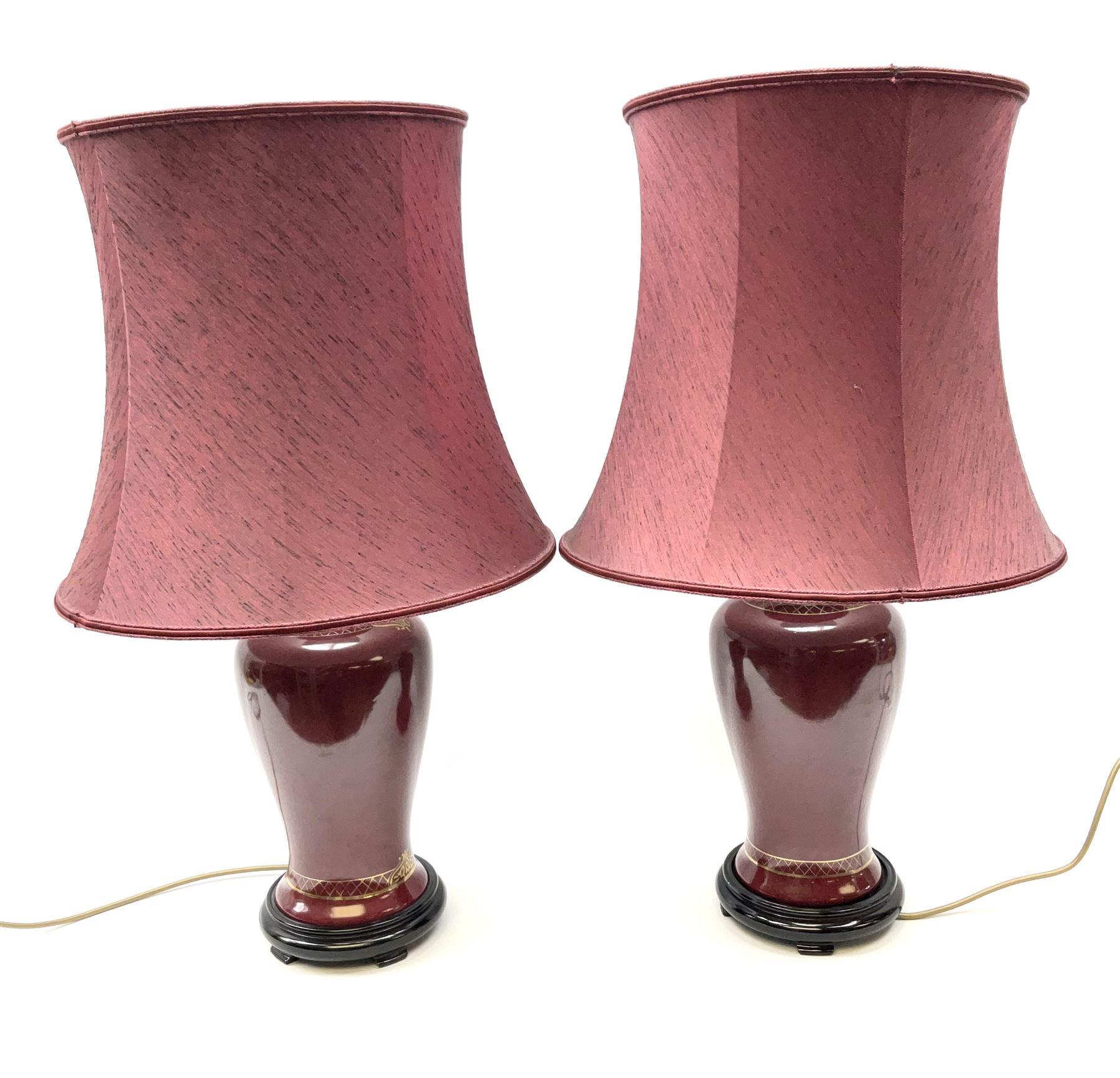 Pair of dark red table lamps in baluster form with a round wooden base