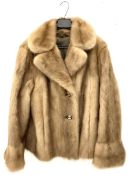 Ladies short blond mink fur button up coat.