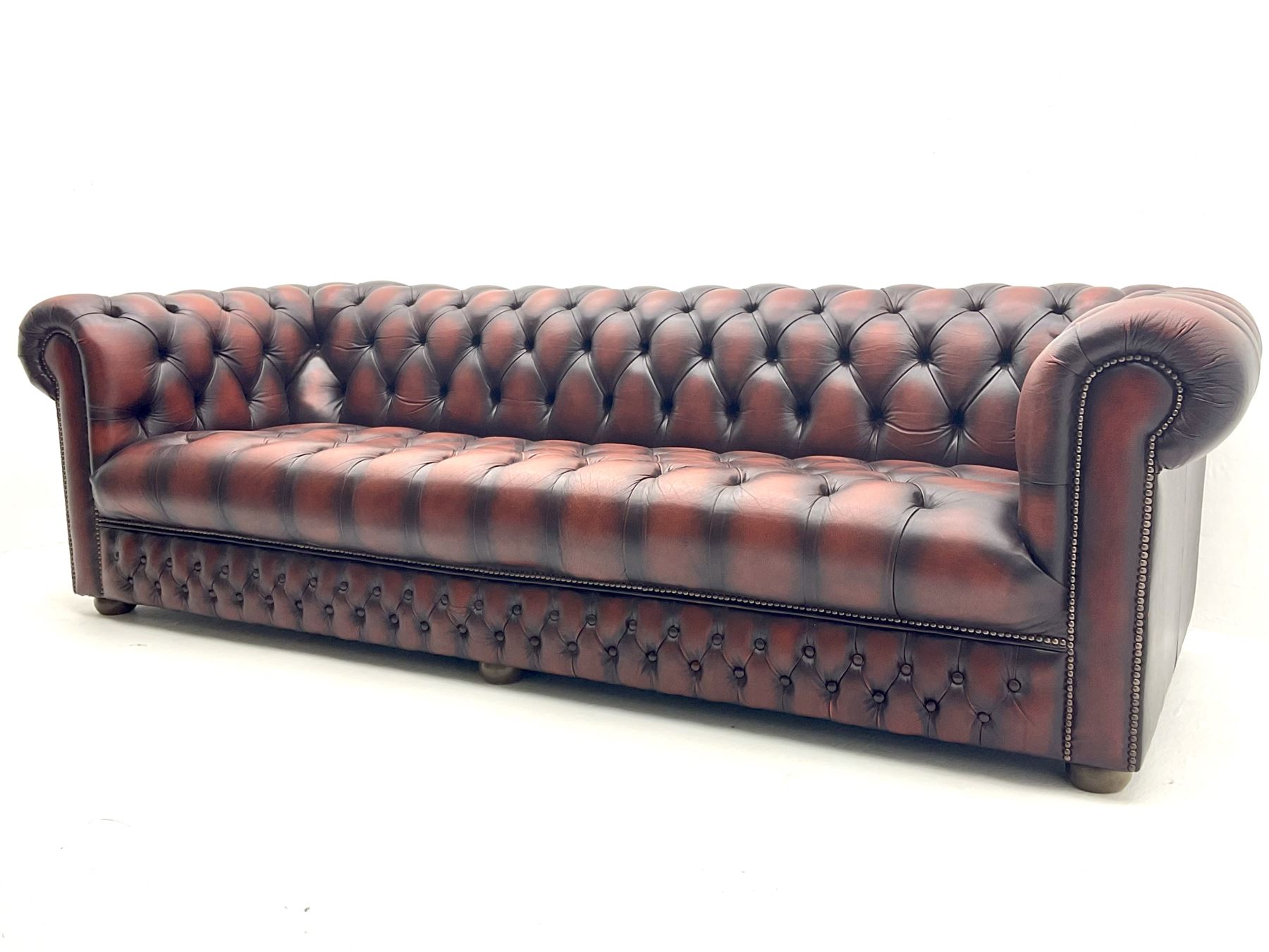Large four seat Chesterfield sofa upholstered in buttoned brown leather