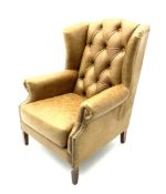 Georgian style wing back armchair upholstered in buttoned and studded tan leather