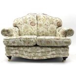 Pair traditional shaped two seat sofas upholstered in floral pattern and cream ground fabric