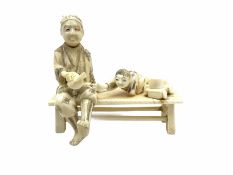 Japanese Meiji period ivory figure of a man with boy on a bench H10cm.