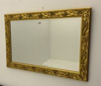 Bevelled edge wall mirror in gilt leaf and berry frame