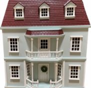 Wooden double fronted three-storey dolls house with pale blue stucco finish and simulated tiled roof