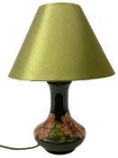 Moorcroft table lamp decorated in the hibiscus pattern on a green ground