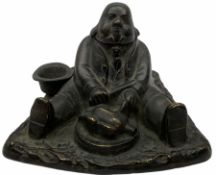 Cast metal inkwell in the form of a man sat eating a roast bird