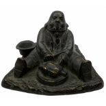 Cast metal inkwell in the form of a man sat eating a roast bird