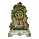 An early 20th century French porcelain clock with rococo scrolling in a cartouche form with gilt hig