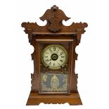 An early 20th century spring driven alarm clock in the style of an American �gingerbread� shelf clo