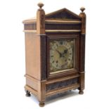 A late 19th century German eight-day mantle clock in an oak case striking the quarters and hours on