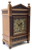 A late 19th century German eight-day mantle clock in an oak case striking the quarters and hours on