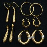 Three pairs of gold hoop earrings and two other pairs of pendant earrings