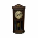 A 1930�s oak cased wall clock with an eight-day going barrel movement striking the hours and half ho