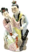 Oriental ceramic figure modeled as a woman reading with a man stood behind her