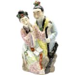 Oriental ceramic figure modeled as a woman reading with a man stood behind her