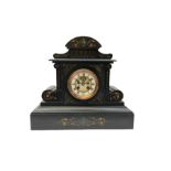 A large late 19th century Belgium slate mantle clock with an arched pediment and supports embellishe