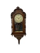 A 19thcentury American wall clock in a walnut case with crossbanding