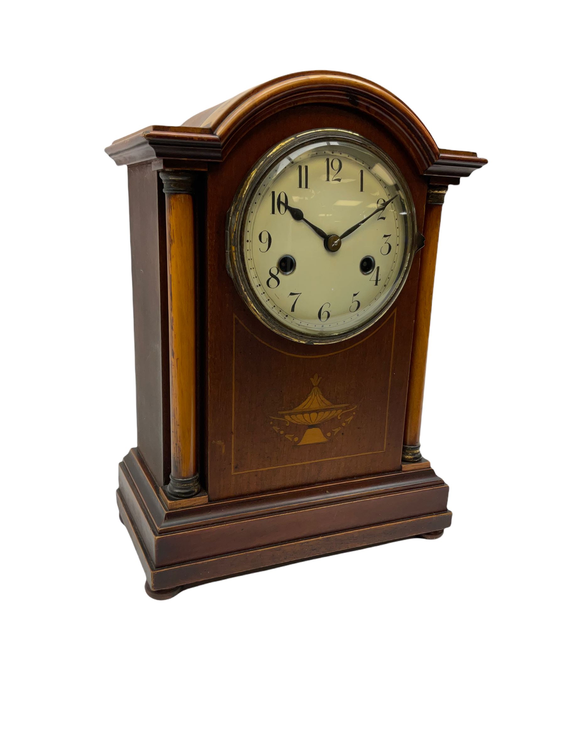 An early 20th century mantle clock in a mahogany case with a break arch pediment