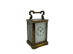 A late 19th century French timepiece carriage clock in a corniche case with a white enamel dial