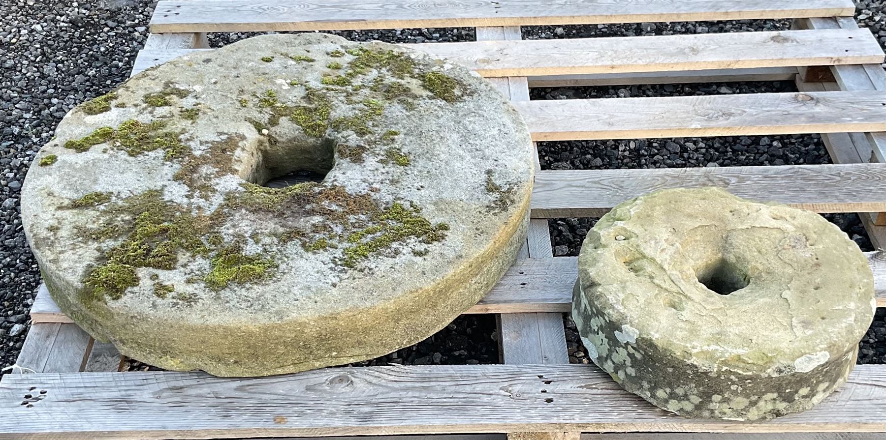 Two 19th century stone mill wheels D64cm and D33cm - THIS LOT IS TO BE COLLECTED BY APPOINTMENT FROM
