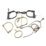 A pair of stirrup spurs, a pair of handcuffs and 3 brass bag locks G+