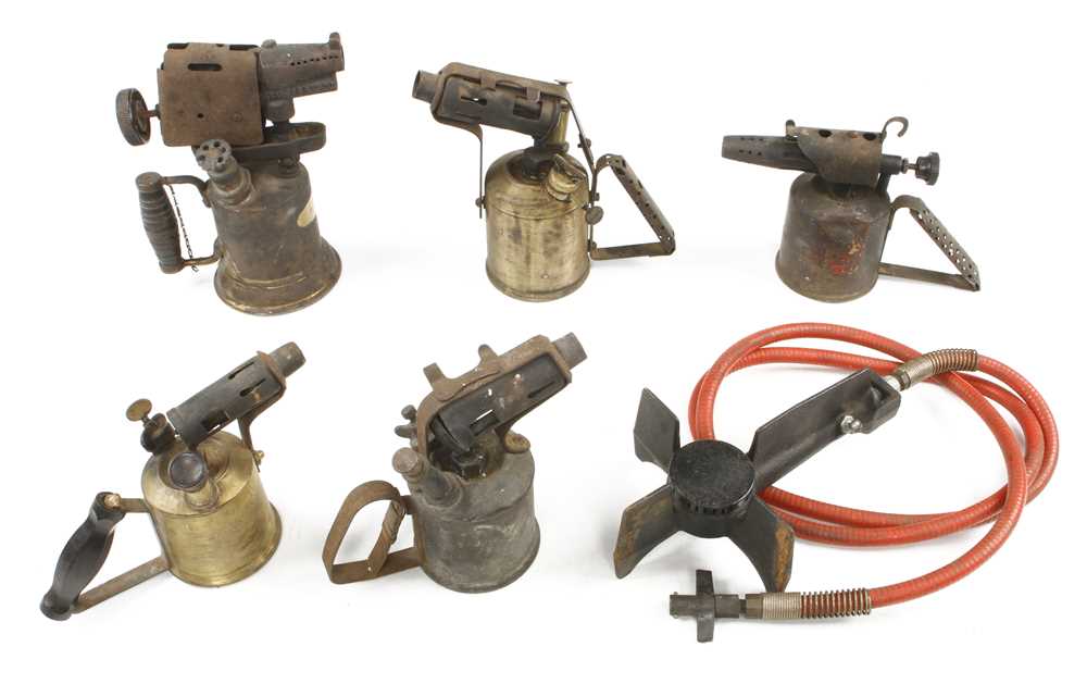 Five brass blow lamps and a burner G