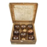 Two sets of lawn bowls in pine box with orig rules the makers label with FELTHAM & Co inside the lid