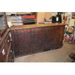 An antique pine tongue and groove shop counter with cupboards to rare