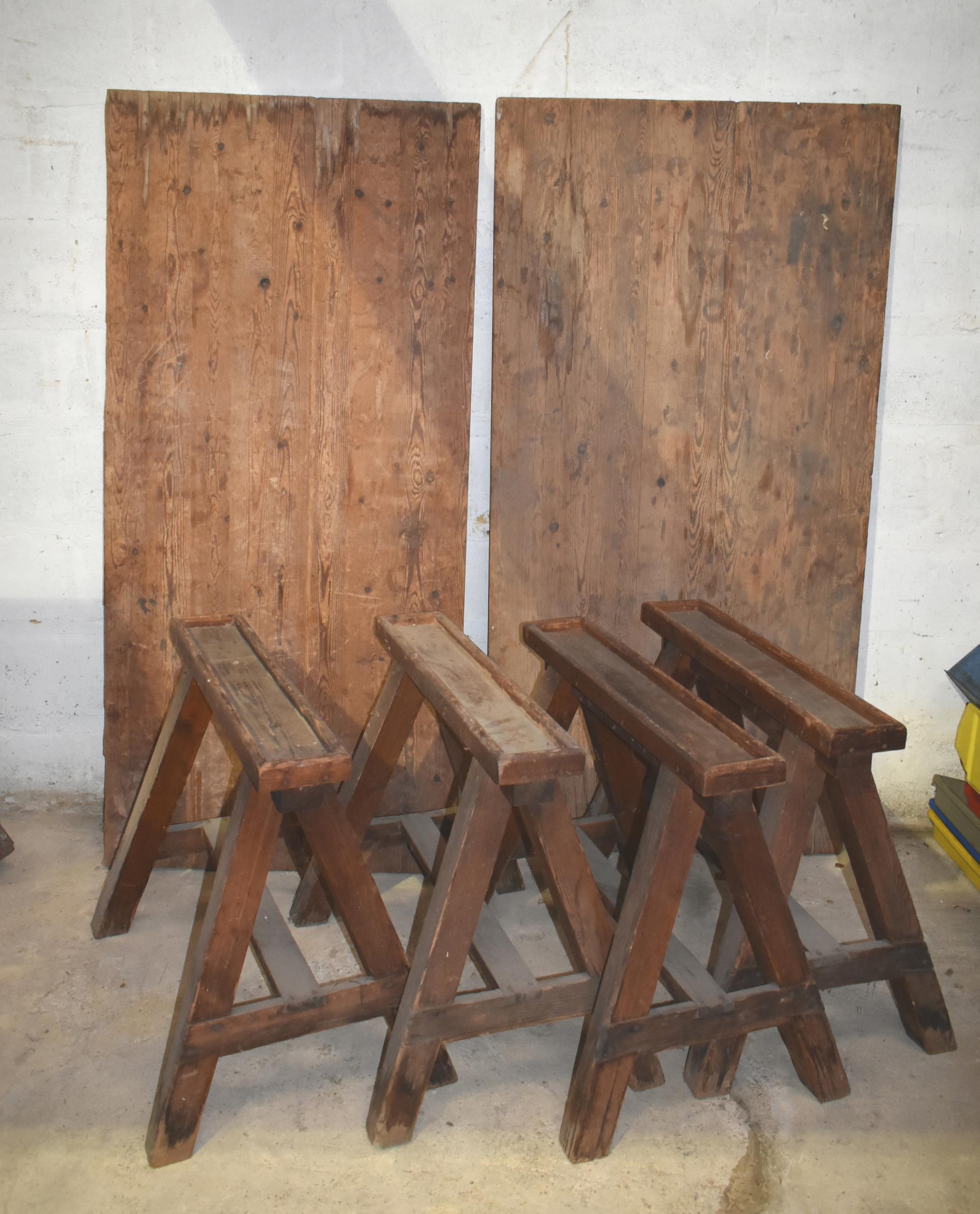 Four upholsterer's wooden trestles c/w two tops