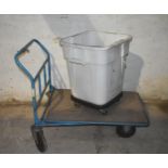 A 4 wheel trolley and a plastic bin on wheels