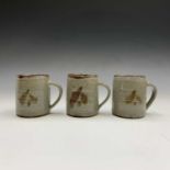 Leach Pottery, St Ives - three mugs with impressed studio seals and Japanese marks. Height 9.5cm.