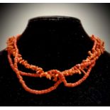 A Chinese coral necklace.Condition report: One of the threads has detached but all coral pieces