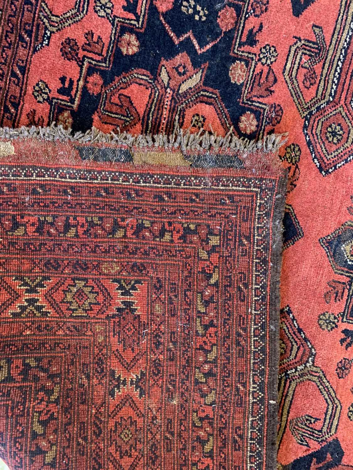 An Afghan carpet, mid 20th century, the madder field with five rows of two polychrome medallions, - Image 3 of 7