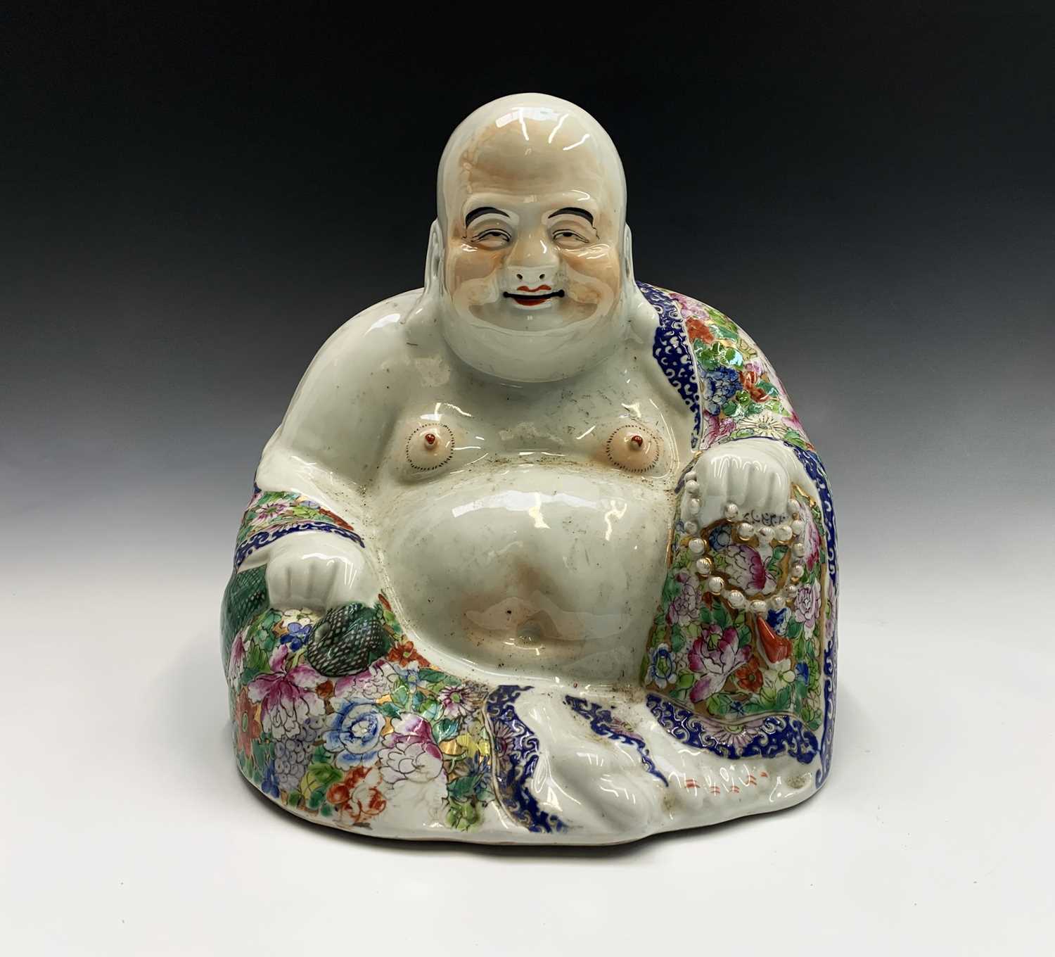 A large Chinese porcelain figure of a seated Buddah, 20th century, wearing a floral decorated robe