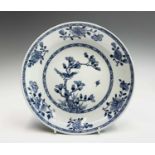 A Chinese blue and white porcelain shallow bowl, 18th century, with a bird perched on a flowering