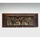 A Chinese carved wood panel, early 19th century, with dancing figures before a fence, 13.5 x 35.5cm.