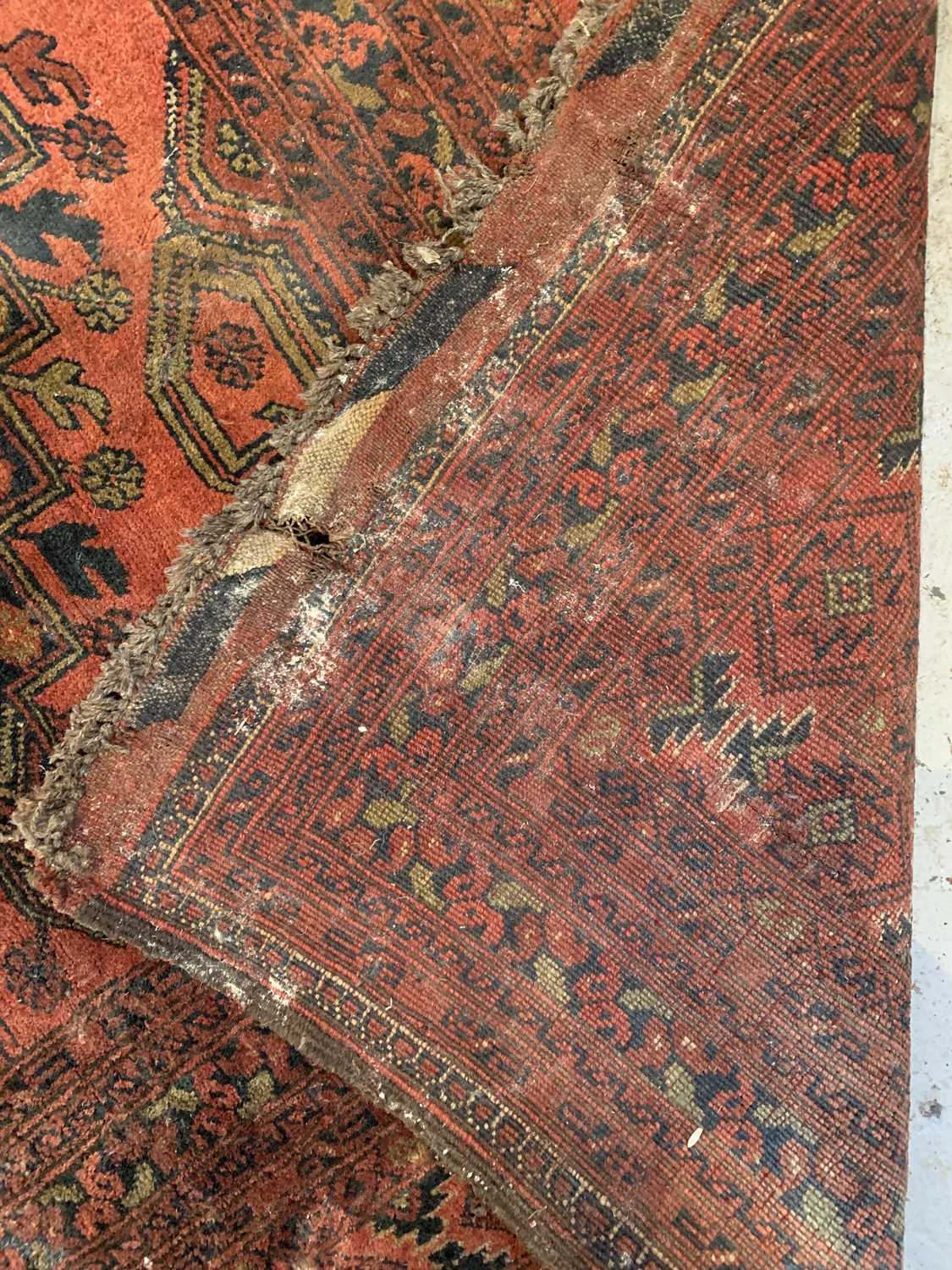 An Afghan carpet, mid 20th century, the madder field with five rows of two polychrome medallions, - Image 7 of 7