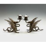 A pair of Chinese patinated brass candlesticks, early 20th century, of dragon form, with scrolled