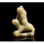 A Chinese jade carving of a diminutive figure, 18th/19th century, riding on the back of possibly a