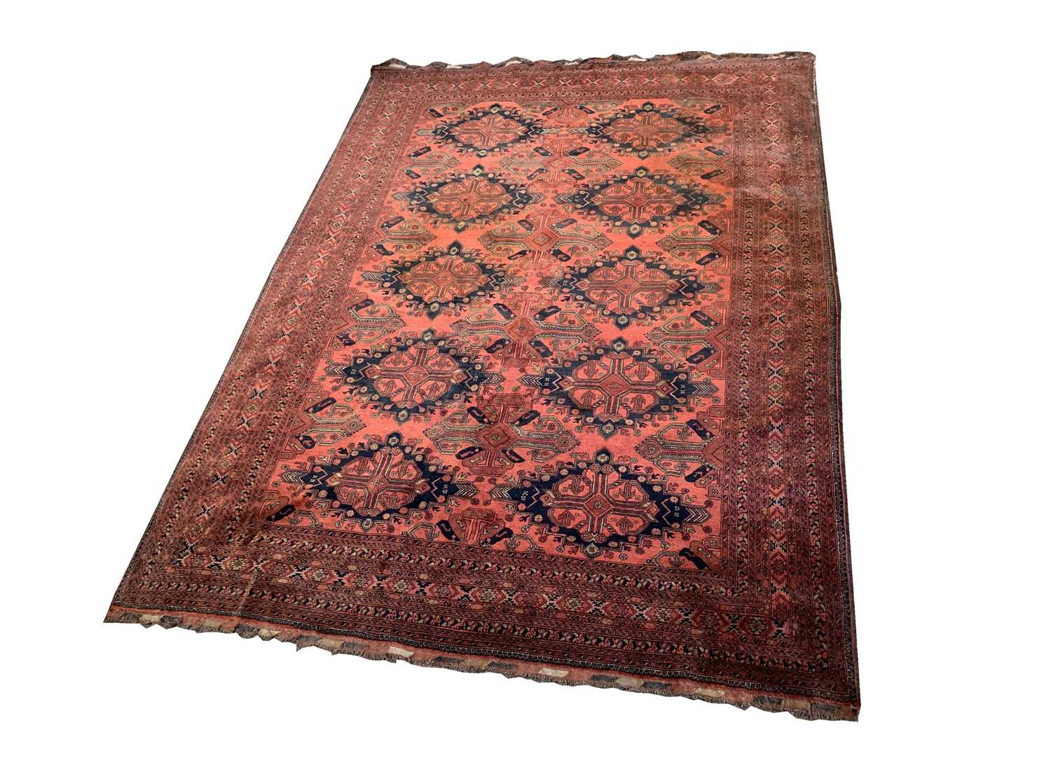 An Afghan carpet, mid 20th century, the madder field with five rows of two polychrome medallions,