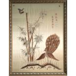 A Chinese silk embroidered picture, 20th century, with butterflies above a peacock and bamboo,