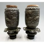 A pair of Japanese bronze urns, Meiji Period, with birds amongst fruiting vines and foliage, heights